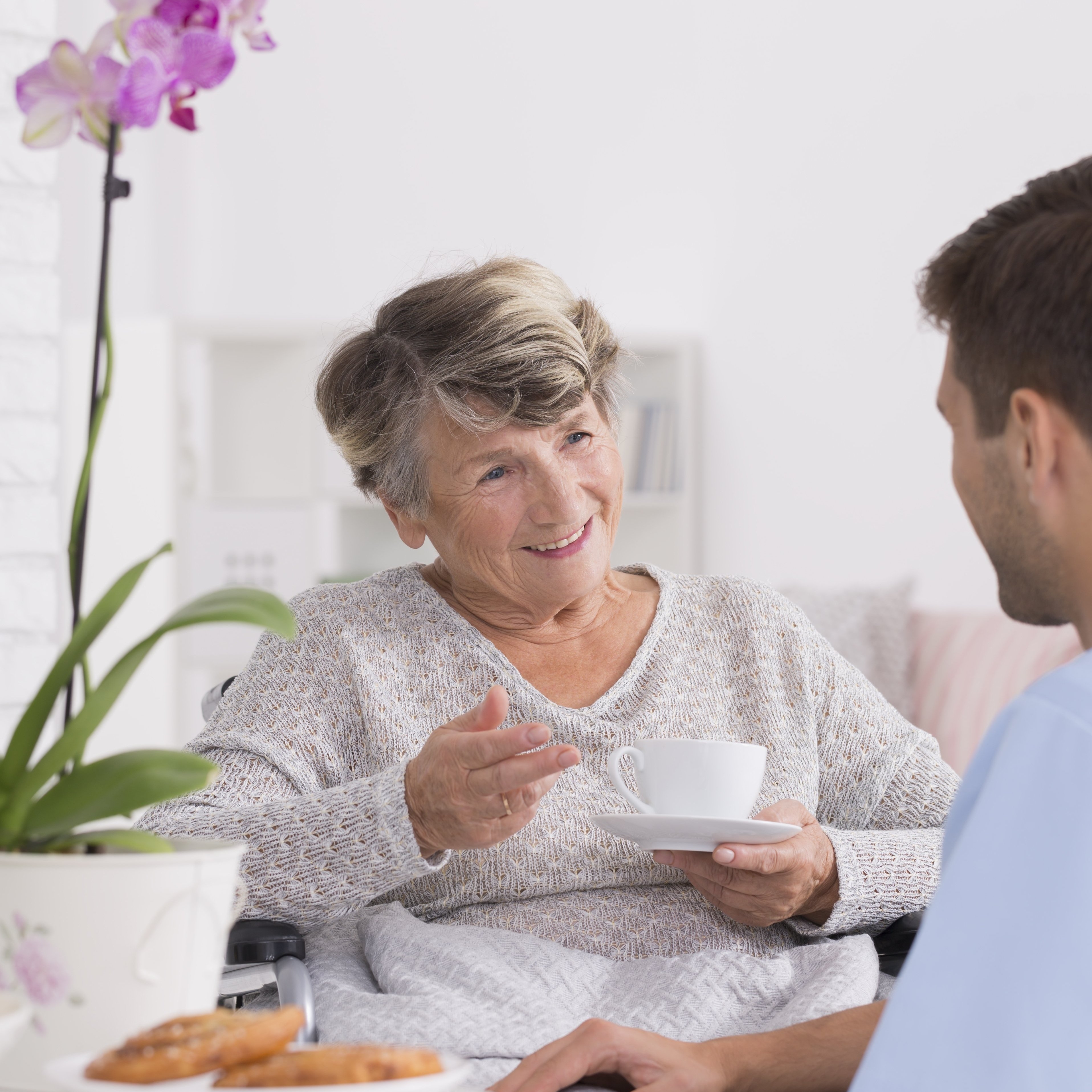 Grandmother talking with caregiver during tea time